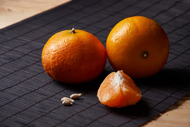 Jugosas mandarinas naranjas sobre una mesa de estilo negro con rojo