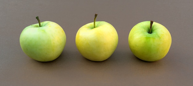 Jugosas manzanas maduras de color verde amarillo sobre un fondo de madera