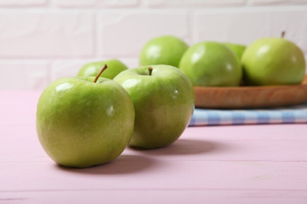 Jugosas manzanas verdes en una mesa de madera