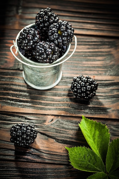 Jugosas moras en balde sobre fondo de madera vintage