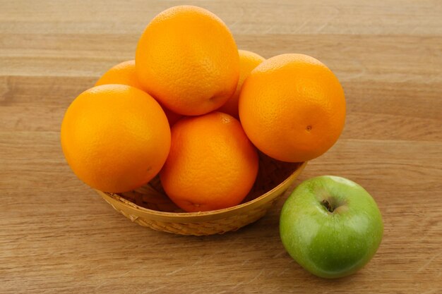 Jugosas naranjas y manzanas en primer plano de la mesa de madera