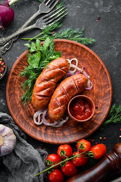 Jugosas salchichas a la parrilla al horno con verduras en un tablero Menú de barbacoa Vista superior