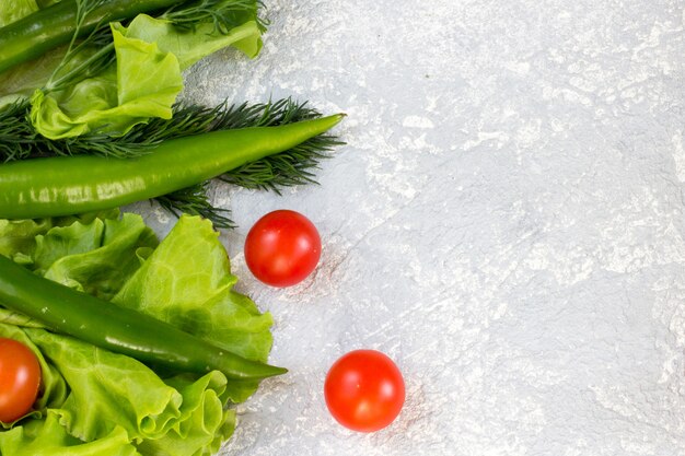 Jugosas verduras y tomates cherry en gris