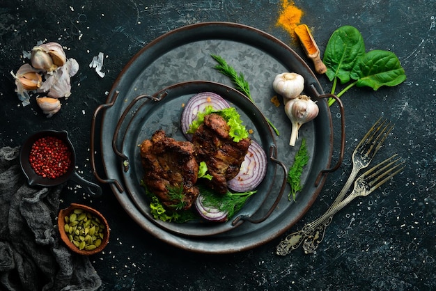 Jugoso filete de cerdo frito con especias en un plato de piedra negra Vista superior Espacio de copia libre