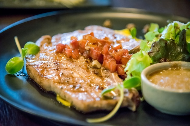 jugoso filete de chuleta de carne con salsa de salsa con ensalada verde y salsa de manzana en negro p