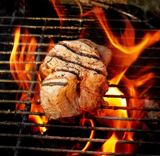 Jugoso y tierno Primer plano de un sabroso bistec cocinando en un fuego