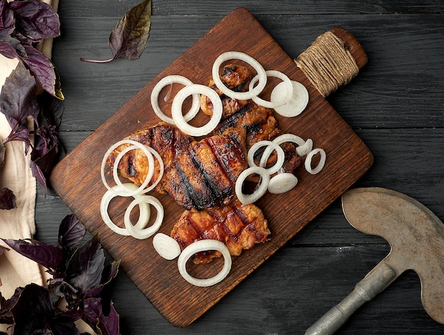 Jugosos filetes de cerdo a la parrilla sobre una tabla de madera marrón