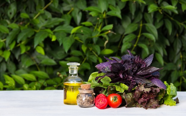 Jugosos tomates, aceite de oliva y verduras para ensalada.