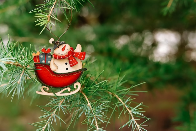 Foto juguete de año nuevo en forma de copo de nieve con santa claus cuelga del árbol de navidad