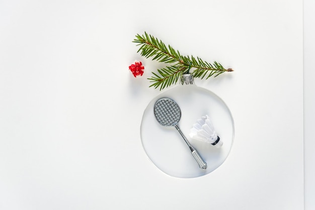 Juguete de árbol de Navidad hecho de pelota de bádminton con plumas y cohetes sobre fondo blanco. Fondo para tarjeta de felicitación, cartel. Enfoque suave, copie el espacio.