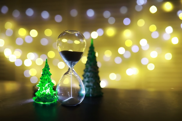 Juguete de árbol de Navidad rojo en una rama de un abeto natural con luces de guirnaldas en desenfoque en el fondo. Juguete de metal con ranuras de ciervo y copos de nieve. Navidad, año nuevo, espacio de copia, bokeh.