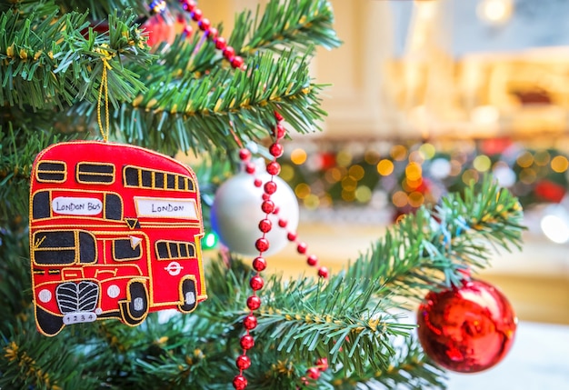 Juguete de autobús de dos pisos y bola de navidad en árbol de navidad