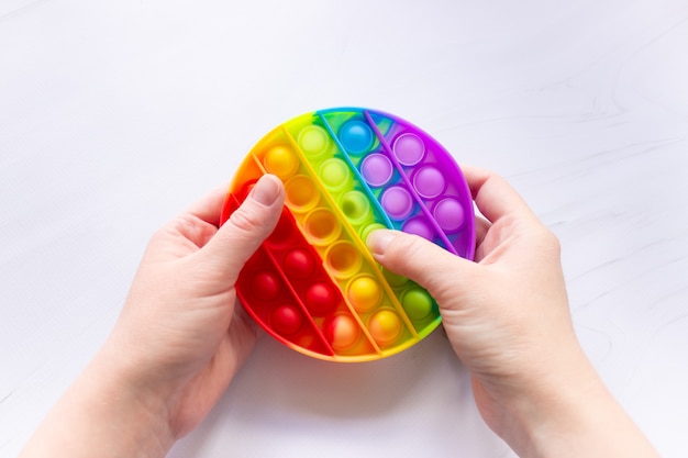 Juguete colorido antiestrés pop it con forma redonda y manos