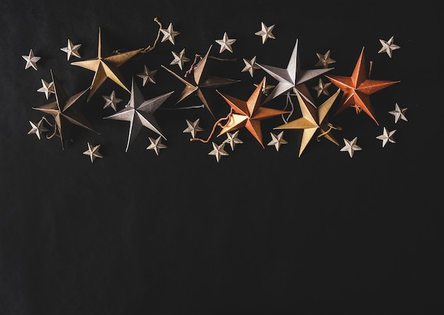 Juguete decorativo de Navidad pequeñas y grandes estrellas sobre fondo negro