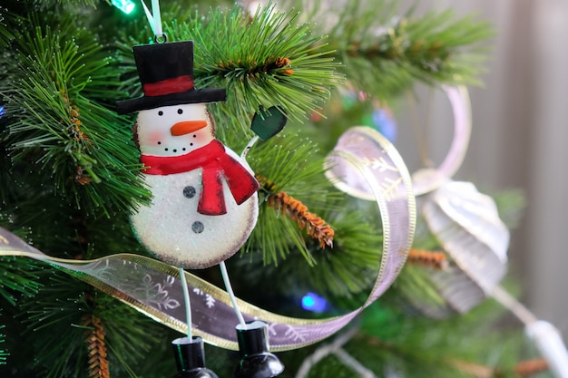 Juguete divertido muñeco de nieve de hierro colgando en el árbol de Navidad.