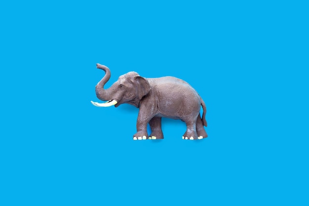 Juguete de elefante de plástico sobre fondo azul.