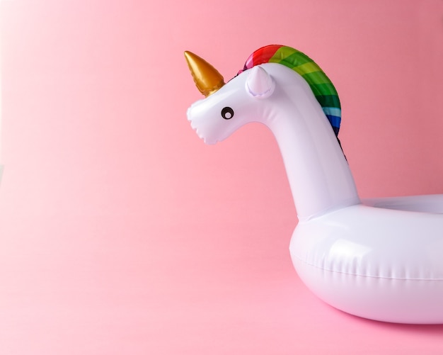 Foto juguete inflable de piscina unicornio aislado en rosa