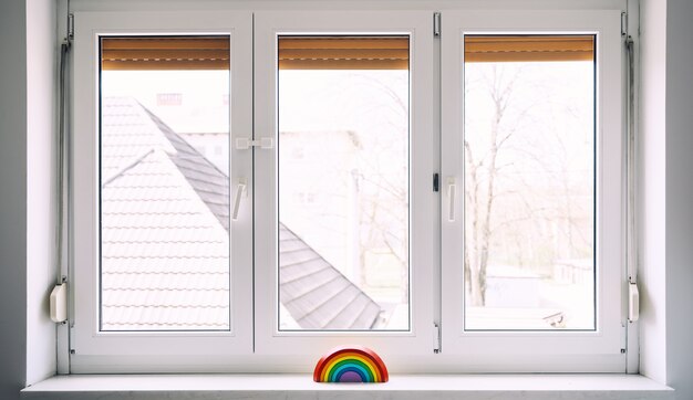 Juguete de madera del arco iris en el fondo de la ventana en la guardería en casa. Fondo de niños.