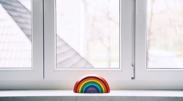 Juguete de madera del arco iris en el fondo de la ventana en la guardería en casa. Fondo de niños.