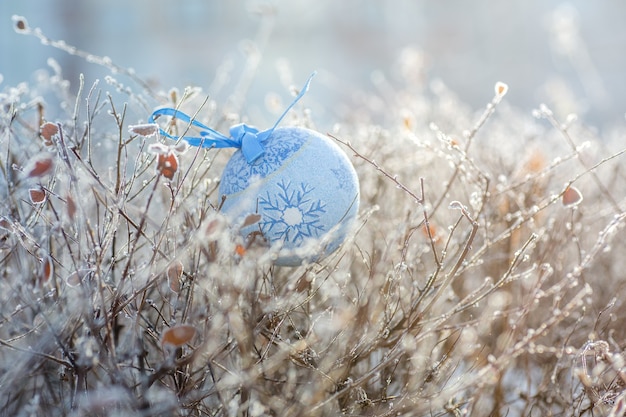 Juguete de Navidad de bola azul de una rama de árbol de Navidad Navidad en la ciudad de fondo para Año Nuevo