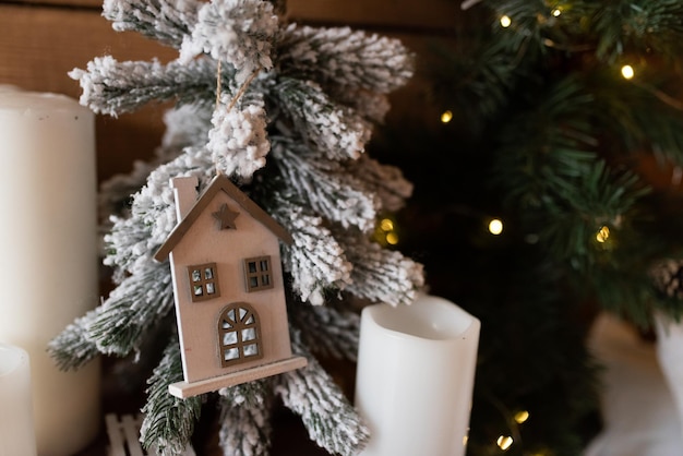 Foto juguete de navidad de casa de madera en el árbol de navidad