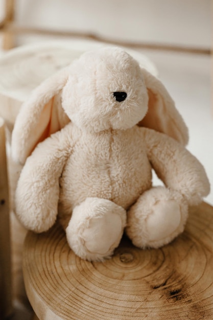 un juguete de peluche de conejo sentado en un claro de madera