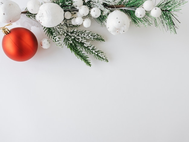 Juguete rojo de Navidad con ramas de abeto y adornos sobre fondo blanco Concepto de Navidad o vacaciones de año nuevo