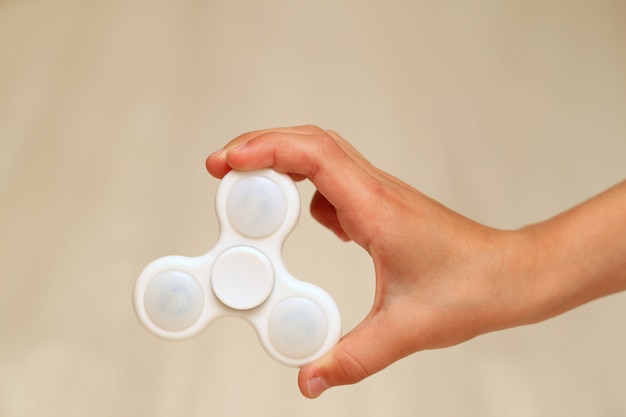 Juguete spinner fidget blanco en mano de un niño
