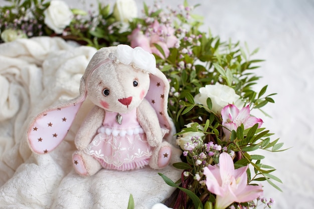 Juguete de Teddy Rabbit en un plaid tejido. Hermoso juguete hecho a mano con estilo con flores