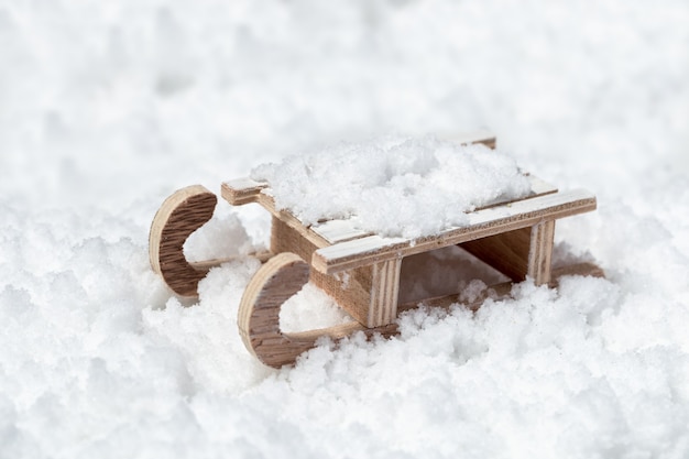 Juguete trineo de madera sobre la nieve con espacio vacío. Concepto para año nuevo o feliz Navidad. Fondo de vacaciones de invierno.