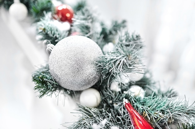 Juguetes de año nuevo en un árbol de Navidad artificial. Bolas en las ramas de abeto cubiertas de nieve