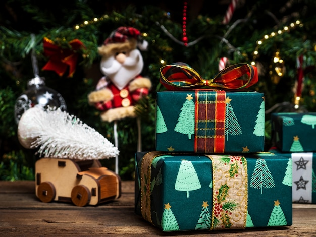 Juguetes de árbol de Navidad en la mesa de madera. Cajas de regalo envueltas.