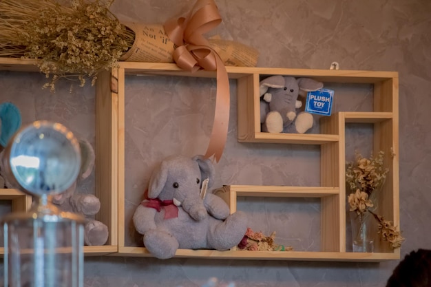 Foto juguetes y flores en estantes contra la pared