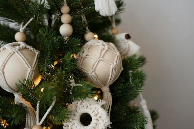 Juguetes hechos a mano cuelgan de un árbol de Navidad artificial