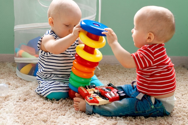 Foto juguetes lógicos educativos para niños. el niño recoge la pirámide de colores. juegos para el desarrollo del niño.