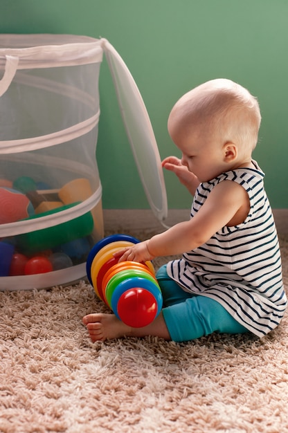 Juguetes lógicos educativos para niños. Un niño recoge una pirámide de colores. Juegos Montessori para el desarrollo del niño. Desarrollo temprano