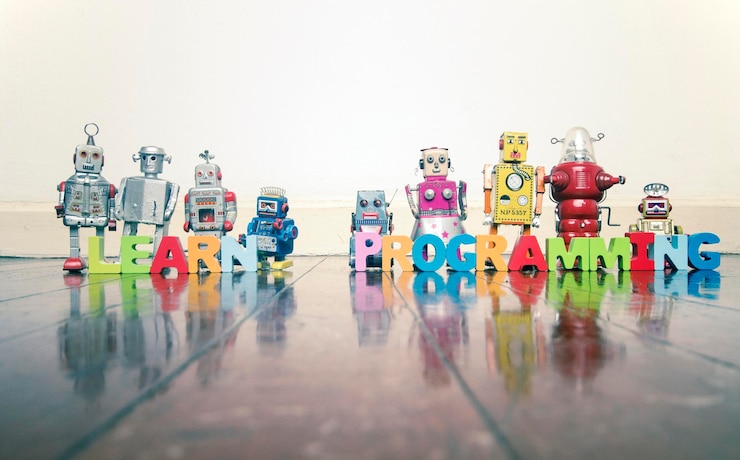 Foto juguetes multicolores, robots y alfabetos en el suelo.