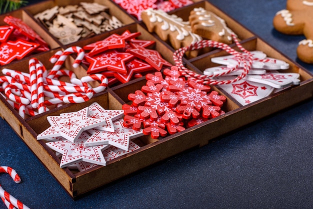 Juguetes de Navidad en blanco y rojo en una caja seccional de madera contra un fondo de hormigón oscuro