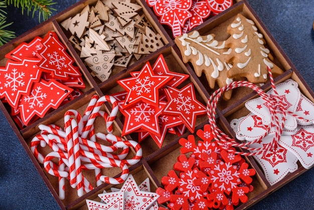 Juguetes de Navidad en blanco y rojo en una caja seccional de madera contra un fondo de hormigón oscuro