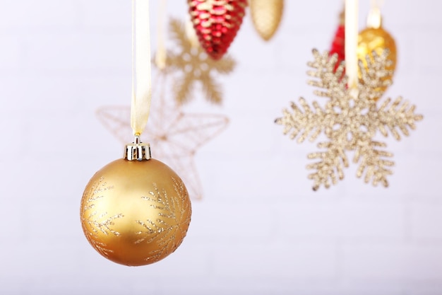 Juguetes de Navidad brillantes colgando de luz de fondo borroso