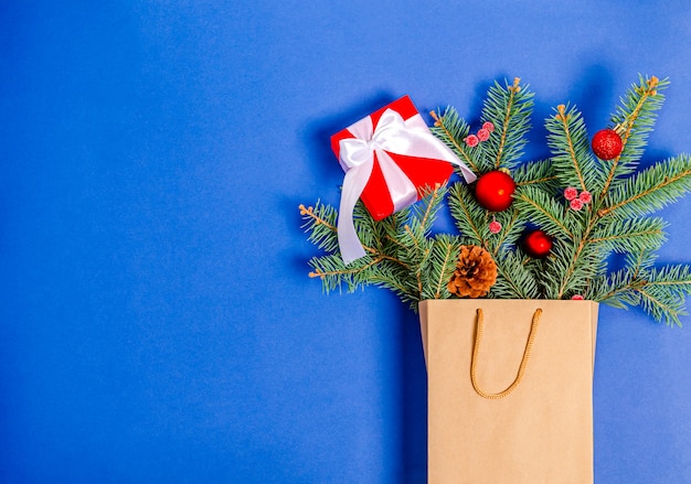 Juguetes de Navidad caja de regalo de cono de pino rama de abeto en una bolsa de compras