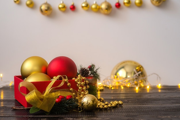 Juguetes de Navidad en una caja roja sobre una mesa de madera