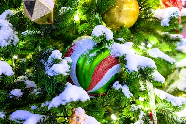 juguetes de navidad en la nieve en el árbol