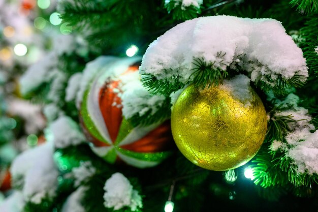 juguetes de navidad en la nieve en el árbol