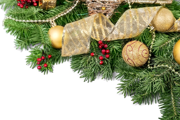 Juguetes de Navidad en la rama de un árbol de abeto, aislado en blanco