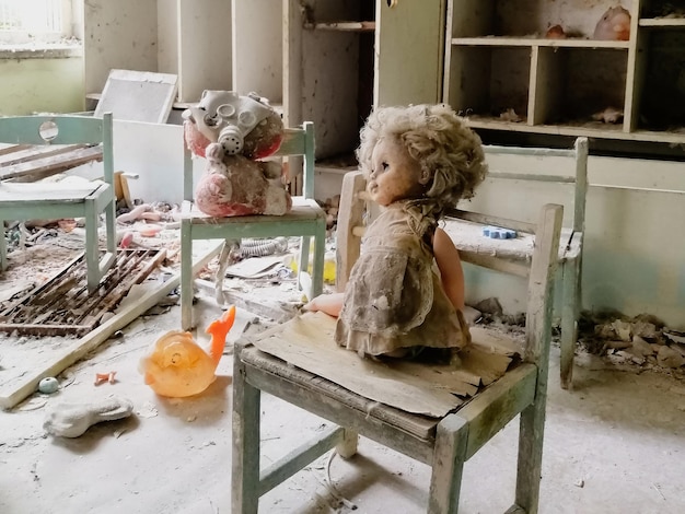 Juguetes para niños cubiertos de polvo y escombros en las ruinas de una casa abandonada abandonada y
