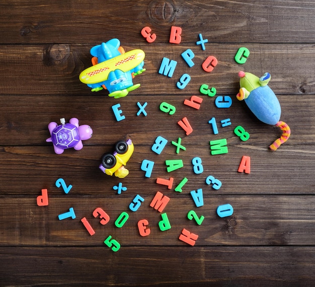 Juguetes para niños y letras de colores en la vista superior de la mesa de madera