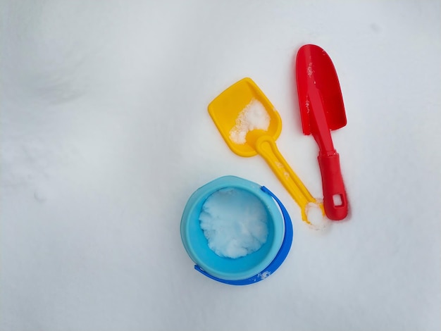 Foto juguetes de plástico coloridos para niños en la nieve