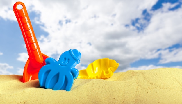 Juguetes de plástico para niños en la playa de arena