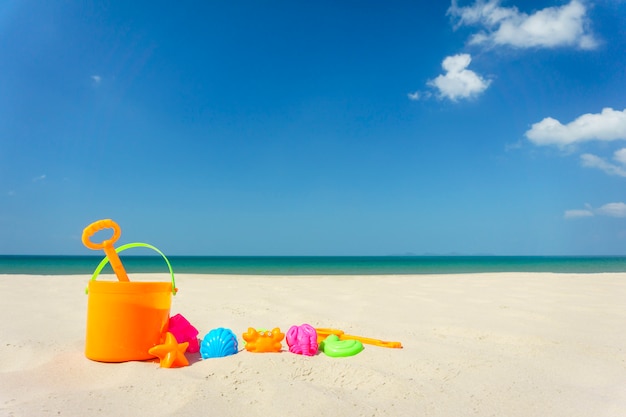 Juguetes de playa para niños en la arena en un día soleado